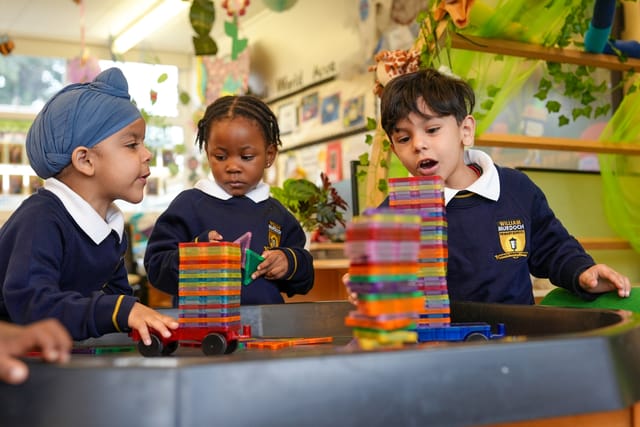 Early years pupils build with colourful magnetic blocks in the classroom.