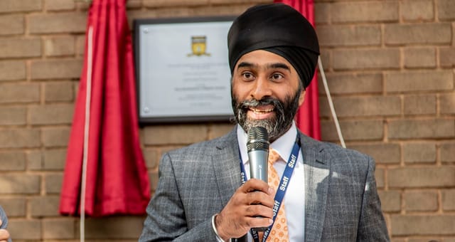 Mr M Singh speaks into a microphone at a school event.